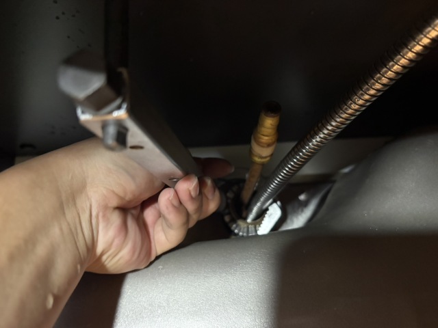 水栓レンチで固定ナットを外す